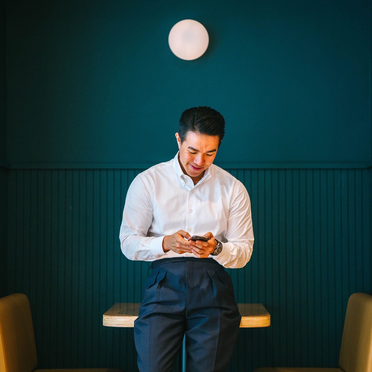Man checking his smartphone while waiting in a restaurant